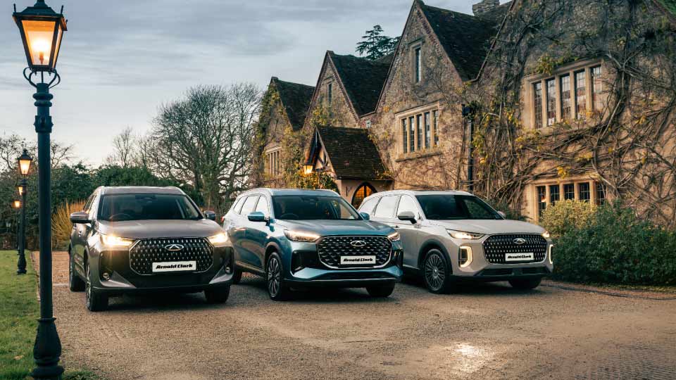 Family camping beside a lake having a meal with Chery Tiggo 8 to the right