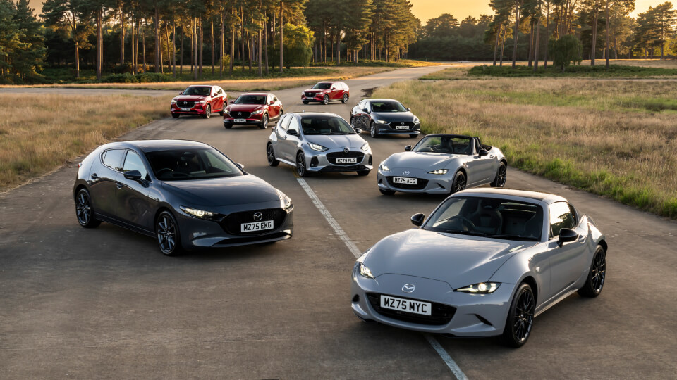Range of Mazda cars spread across a country road